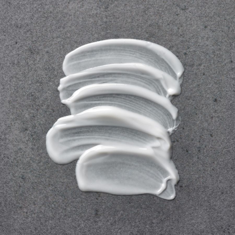 Close-up of white sunscreen cream smeared to demonstrate How to Brighten Dull Skin